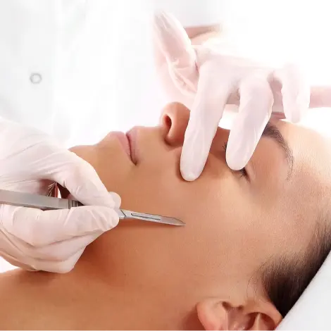 Close-up of a client receiving dermaplaning at La Maison Beauté, a gentle exfoliation technique performed by a skilled practitioner using a sterile blade to remove dead skin cells and vellus hair, revealing a smoother and more radiant complexion.