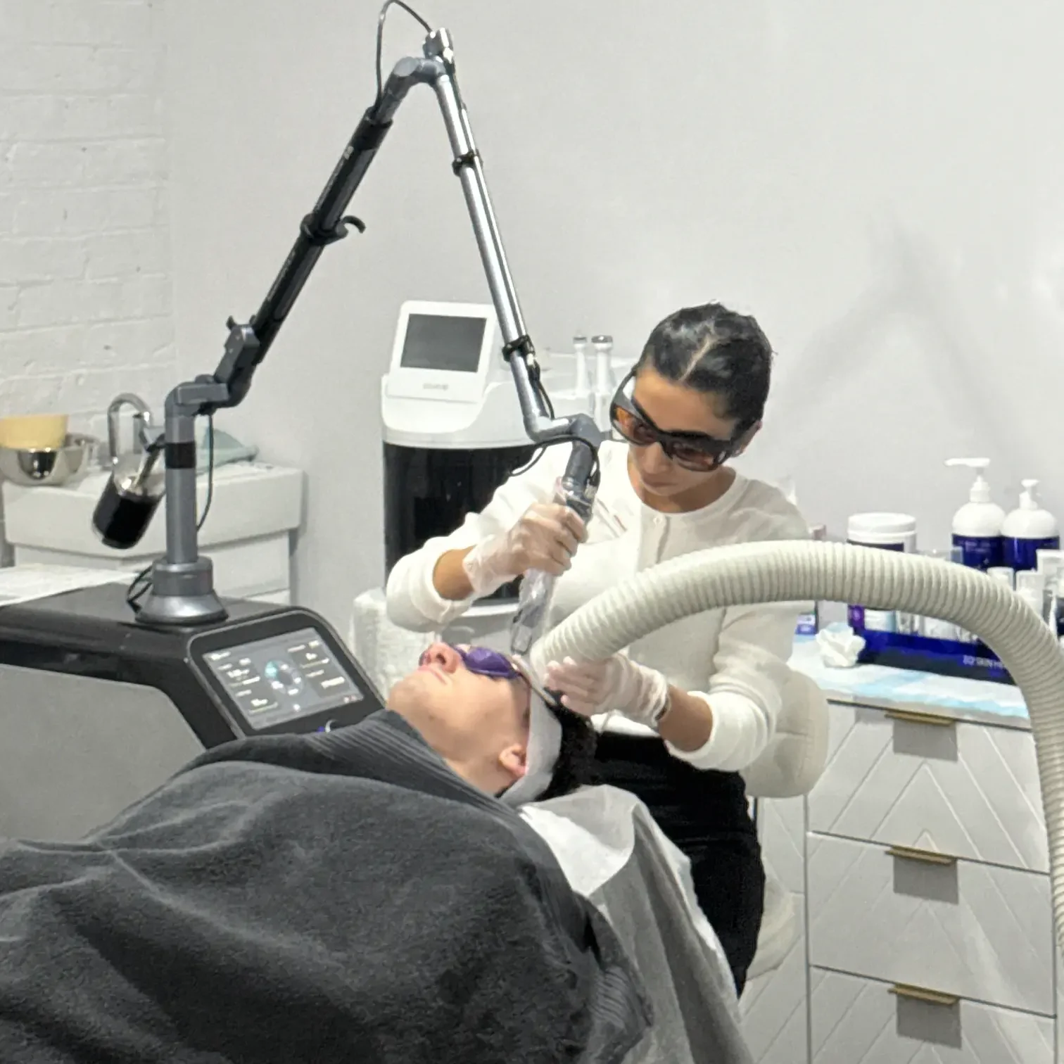 Anushka performing a laser skin treatment on a client in the calm clinic