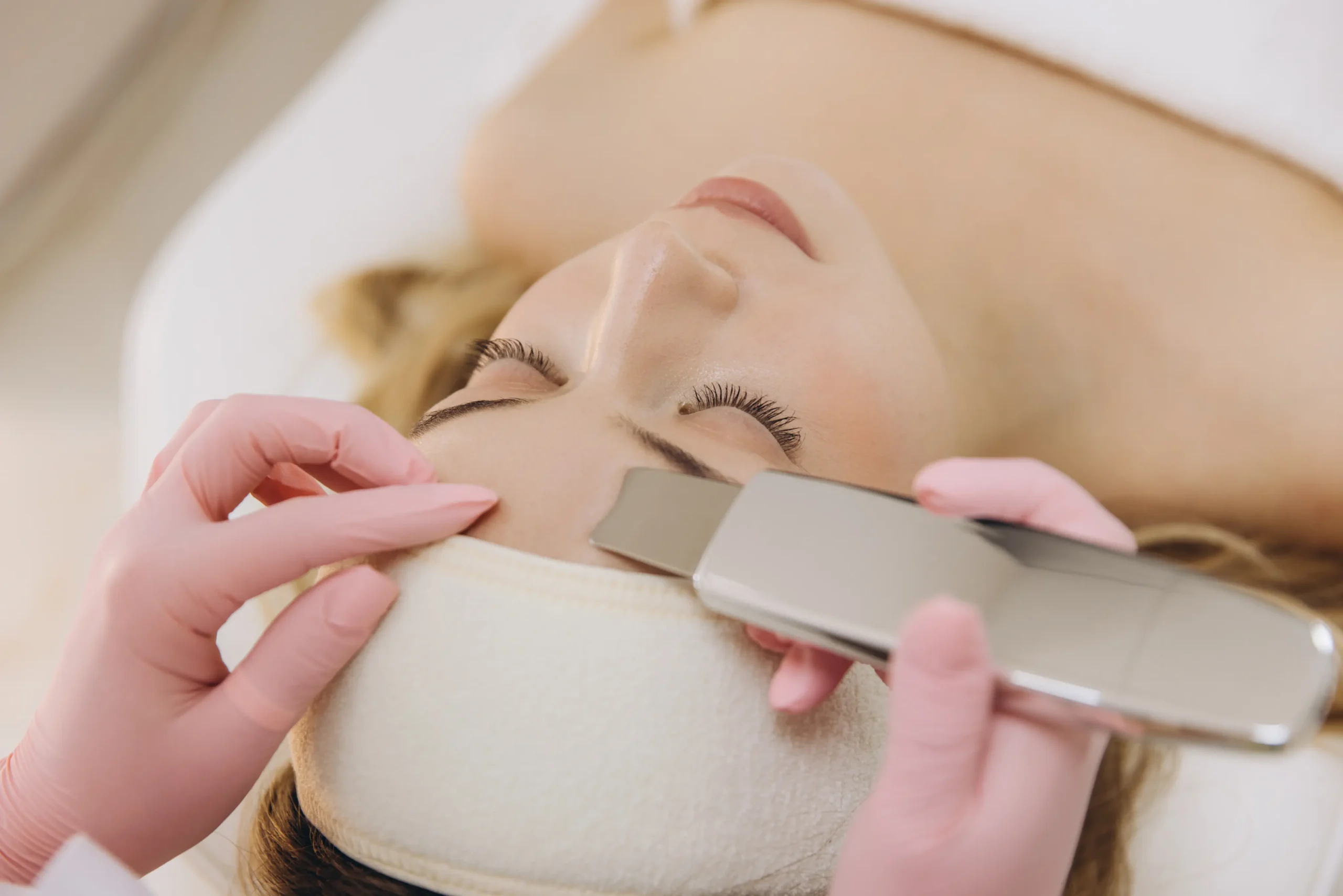 The image shows a close-up of a client receiving a Dermaplaning treatment, a skin-rejuvenating procedure.