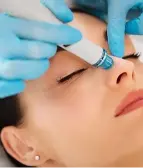 A woman receiving an Aqua Pure Facial, a supercharged hydra facial that exfoliates, lifts, and infuses skin with glow-boosting serums.