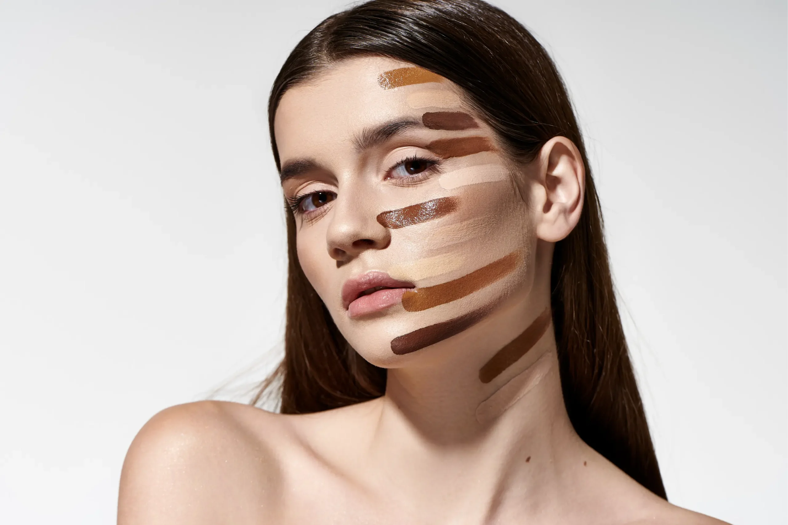 A woman undergo with different foundation shades being tested on her skin.