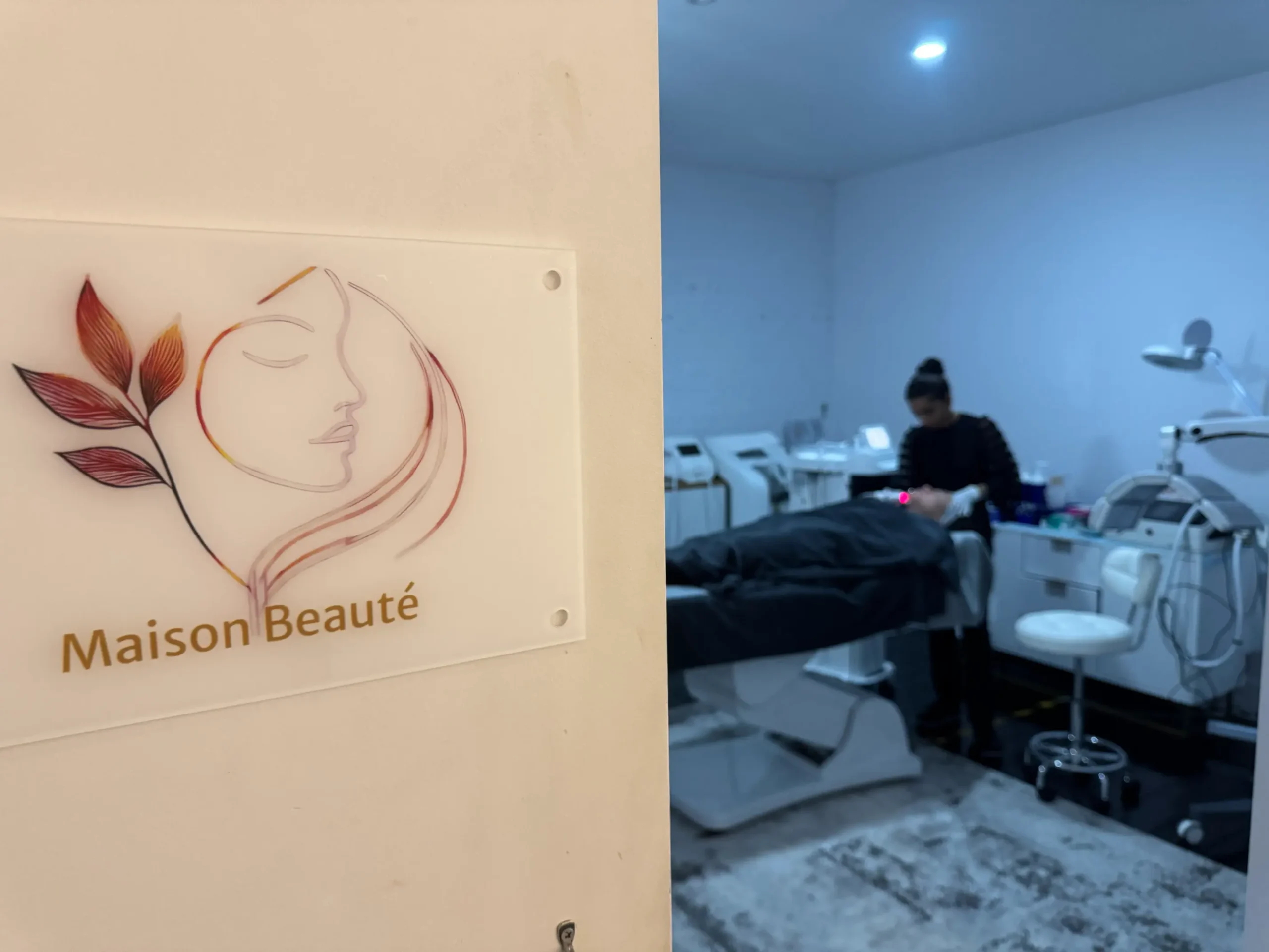 A welcoming display for "La Maison Beauté," a cosmetic clinic in South Melbourne, featuring their logo and a glimpse into their advanced skincare treatments.