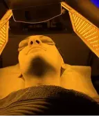A client undergoing a MEDICAL LED LIGHT TREATMENT using targeted wavelengths to address specific skin concerns: blue light for acne, yellow light for calming and boosting circulation, and red/infrared light to stimulate collagen for smoother, rejuvenated skin at La Maison Beauté.