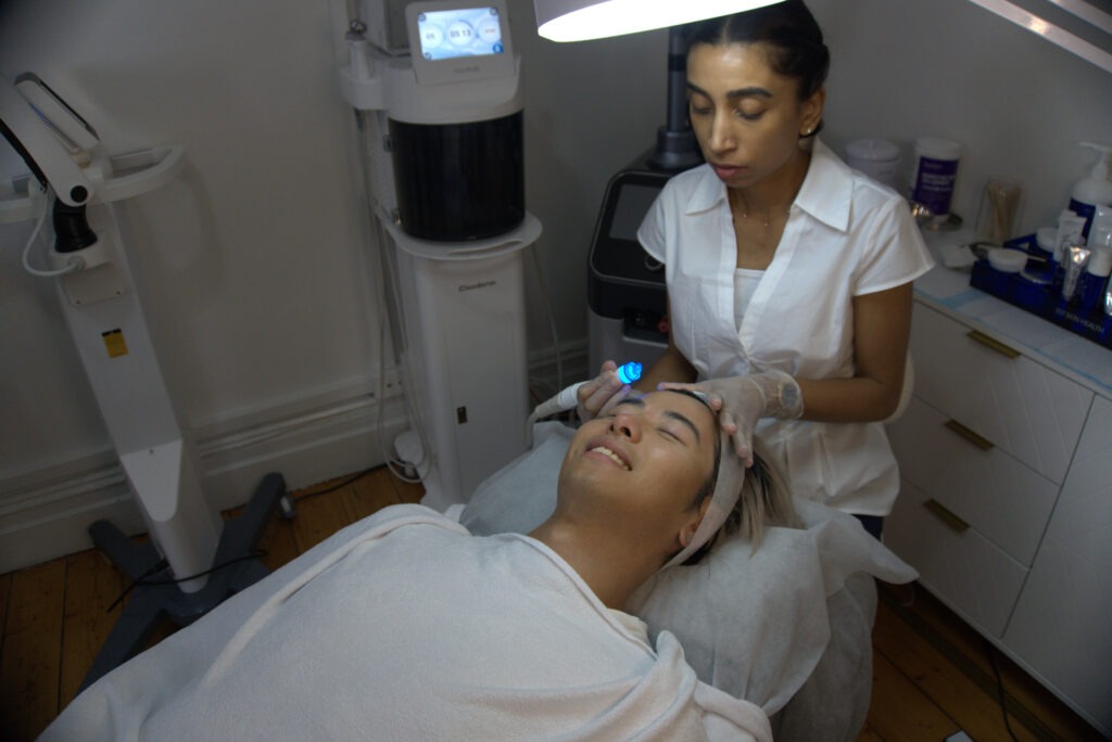 Anushka soothes a client while applying a hydrafacial treatment