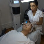 Anushka soothes a client while applying a hydrafacial treatment