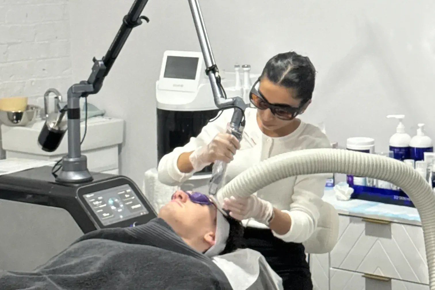 Anushka performing a laser skin treatment on a client in the calm clinic