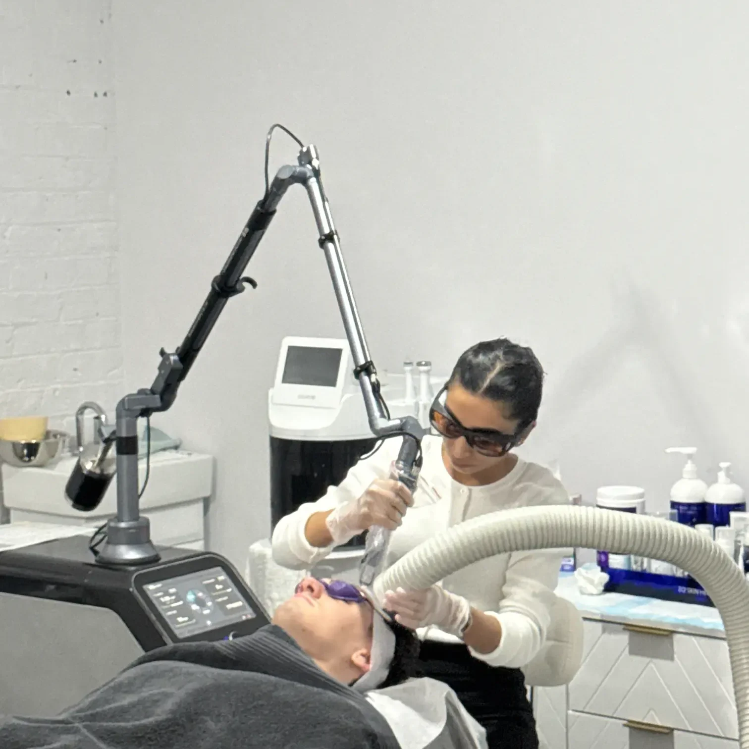 Anushka performing a laser skin treatment on a client in the calm clinic