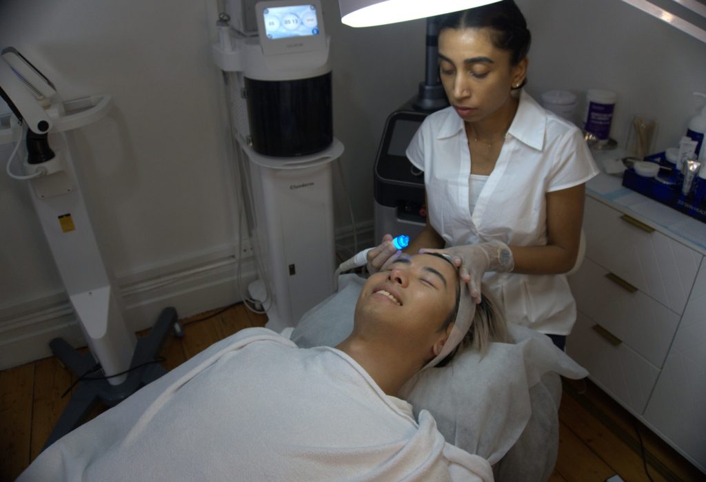 Anushka soothes a client while applying a hydrafacial treatment